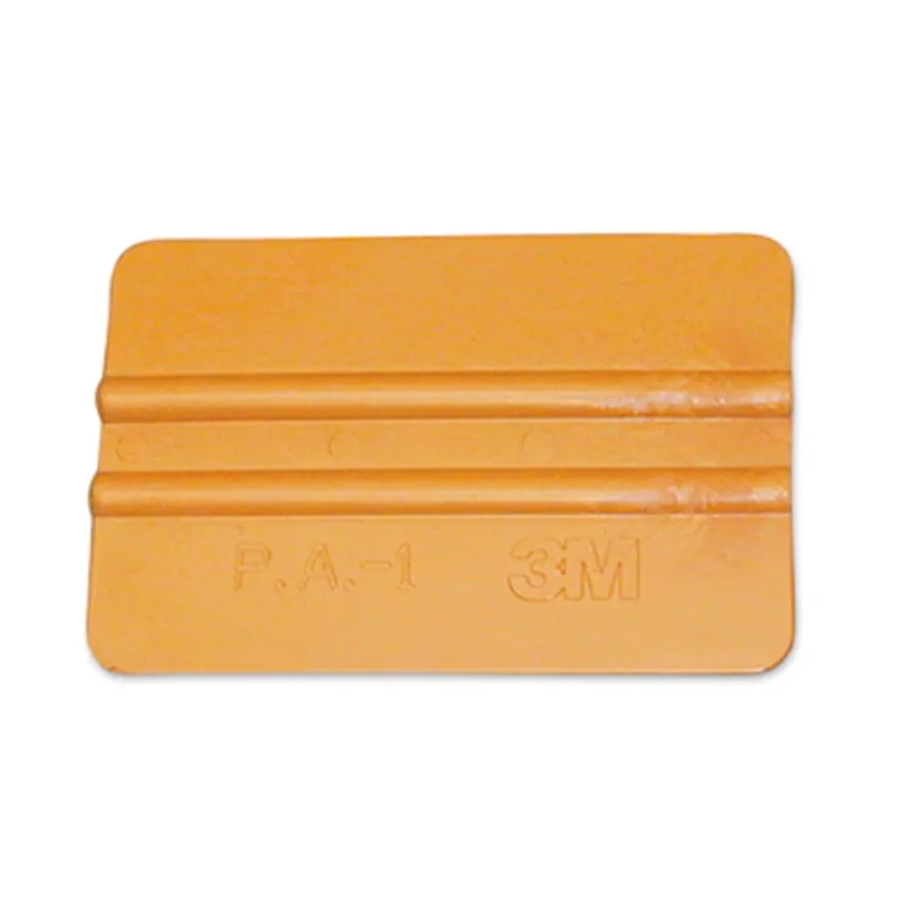 Espátula 3M PA-1-G dorada flexible y reutilizable, con borde reforzado de nailon para aplicar láminas y vinilos sobre superficies texturizadas.